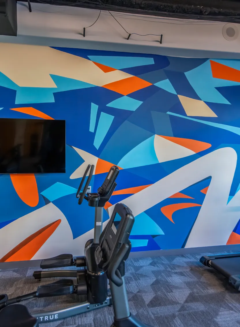Contemporary artwork with angular forms and layered colors decorating a modern gym